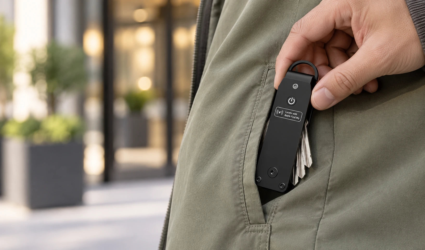 Hand slipping a folded black key organizer into a jacket pocket.