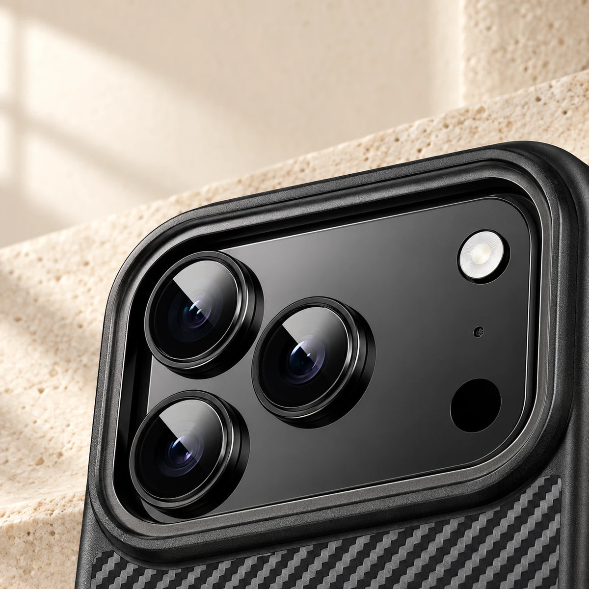 Close-up of the raised black camera surround on a carbon-pattern phone case.