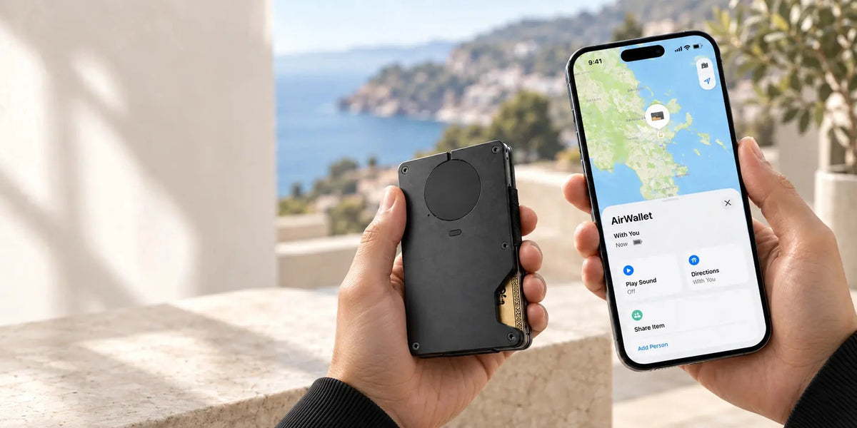 Black metal tracker wallet beside a phone displaying a wallet location map.