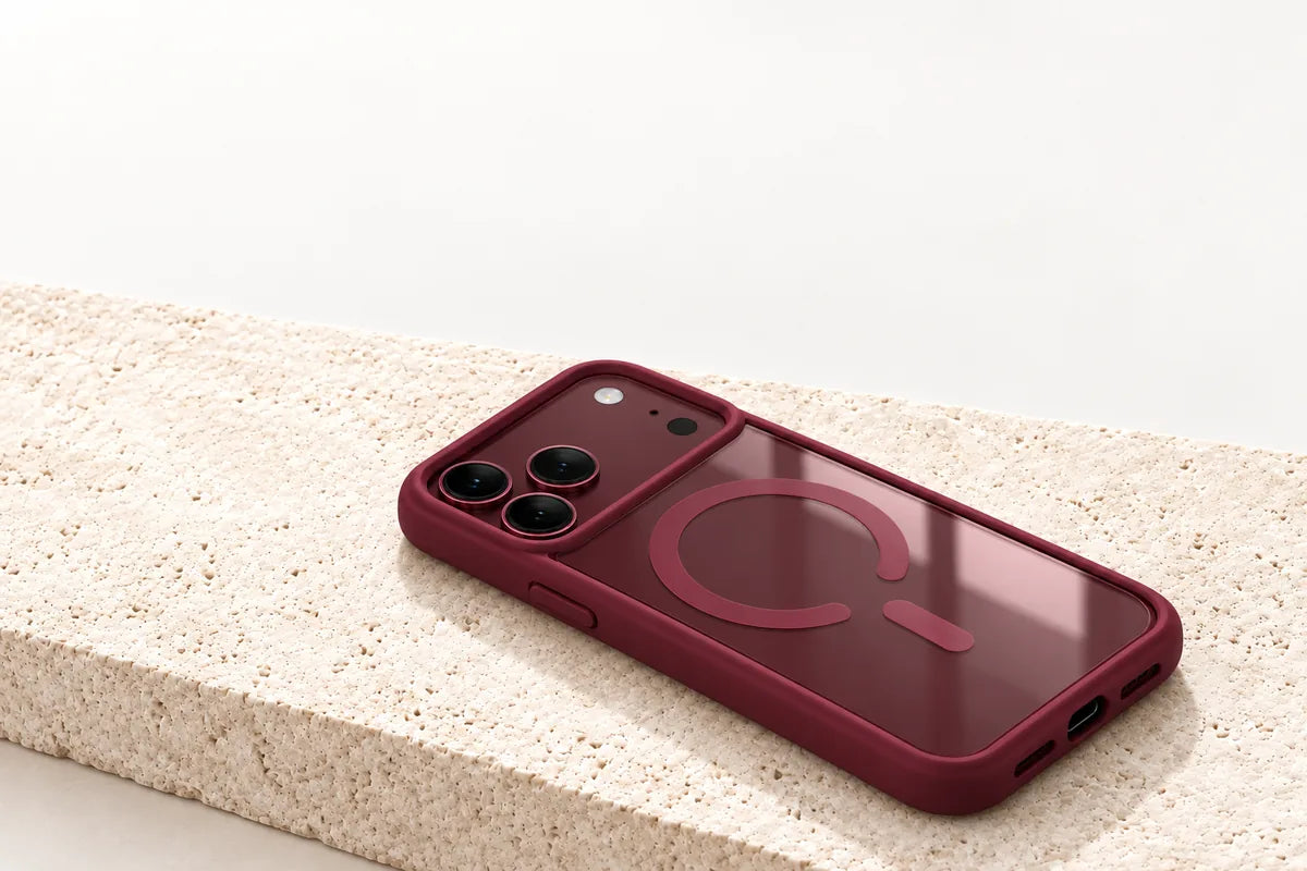 Burgundy clear back phone case resting diagonally on a pale stone slab.