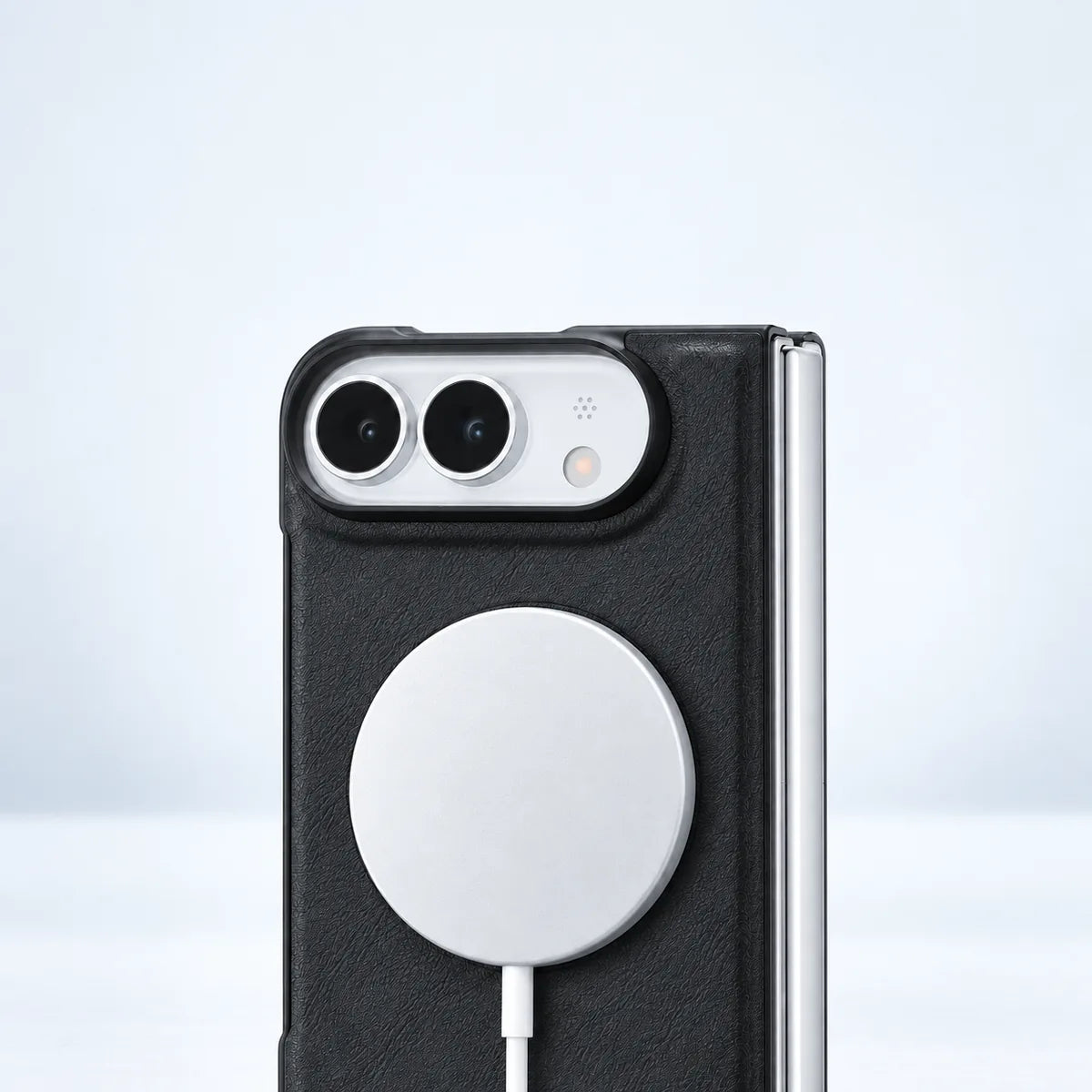 White magnetic charging puck attached to the back of the black phone case.
